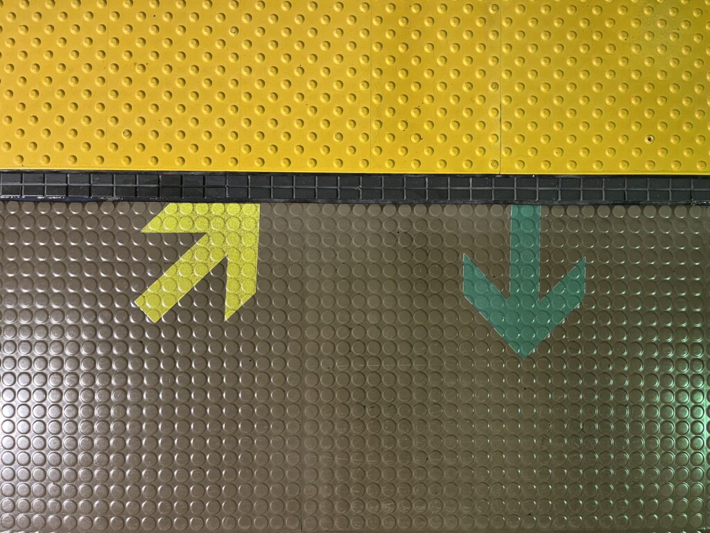 Yellow and green arrows on a rubber floor