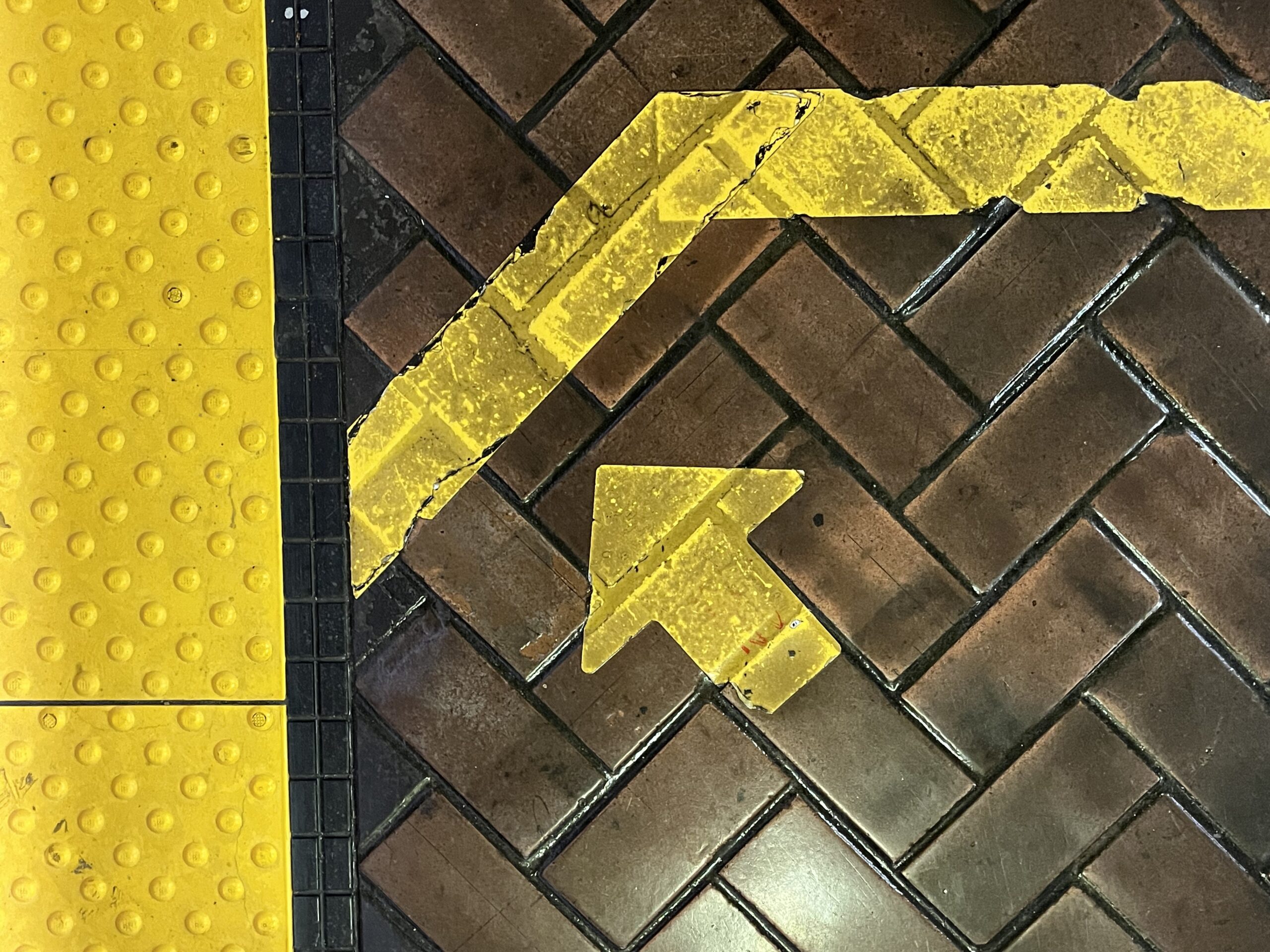 Yellow arrow painted on bricks