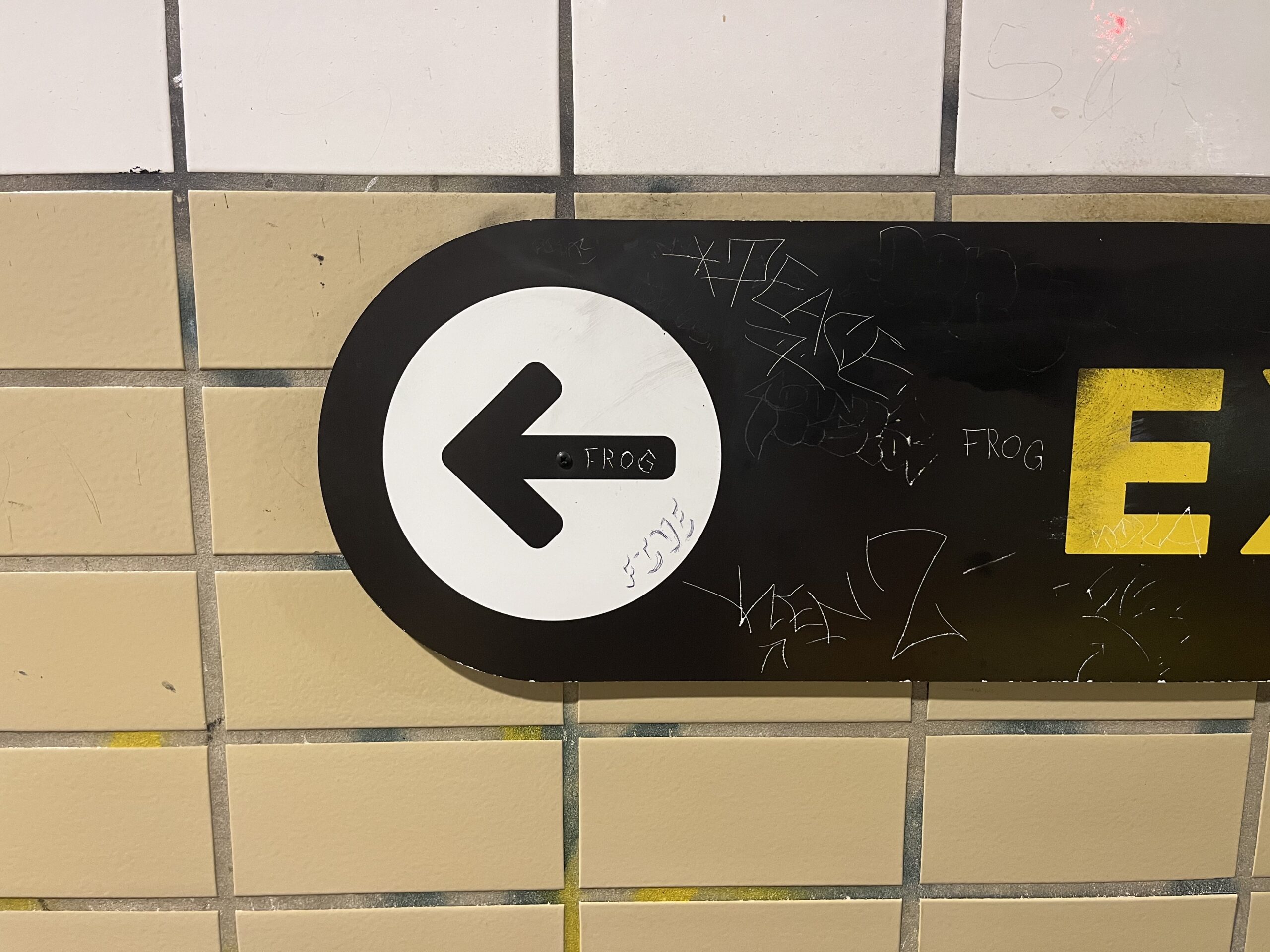 Black arrow in a white circle on a black sign