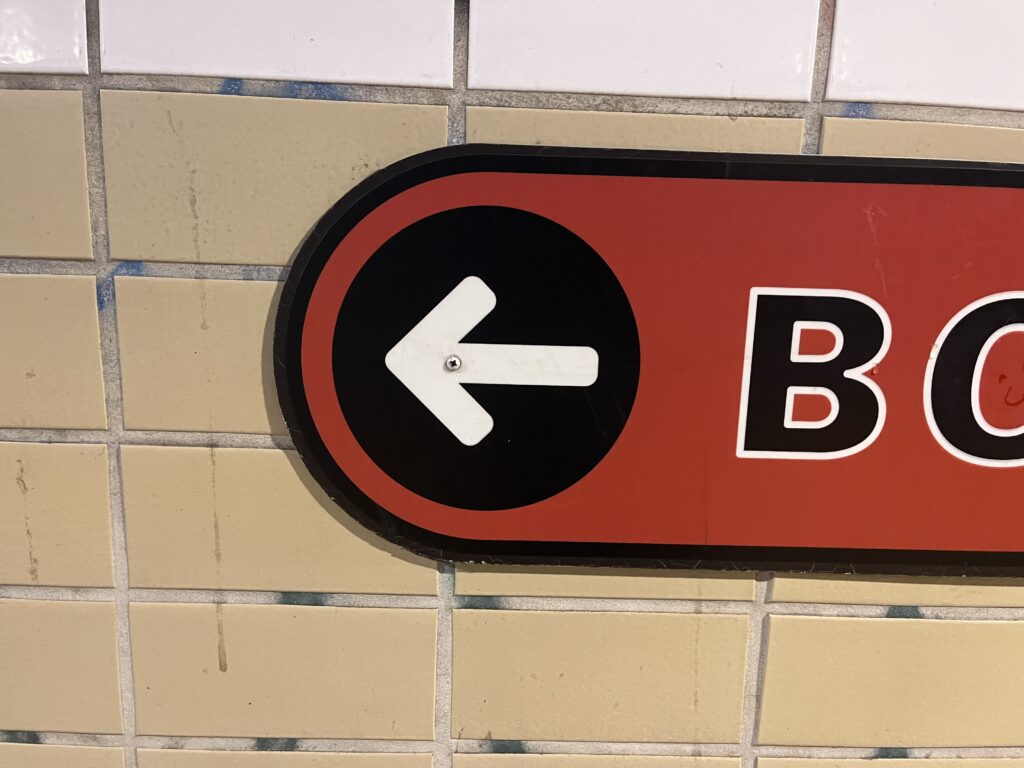 White arrow in a black circle on a red sign